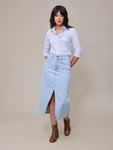 Camisa celeste a rayas verticales blancas, de manga 3/4 con puños arremangados y cuello clásico.