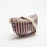 Riñonera de tela con estampado de rayas azules y rosadas, cierre superior con cremallera dorada y correa ajustable color beige. Incluye etiqueta frontal con la inscripción "GET IT.".