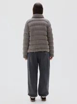 Campera acolchada con estampado de pata de gallo en tonos neutros, cuello alto y cierre frontal completo.