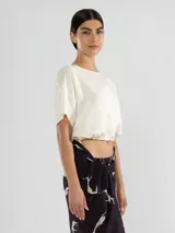 Top corto color crudo de lino tencel, con mangas cortas y lazo ajustable en el ruedo.