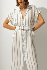 Vestido camisero midi a rayas verticales color blanco y beige, con cuello camisero, mangas cortas con dobladillo, cierre frontal con botones y cinturón con hebilla forrada.