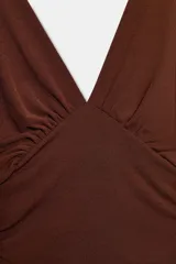 Top marrón con textura, escote en V pronunciado, mangas amplias por debajo del codo tipo capa y detalles de pliegues laterales.