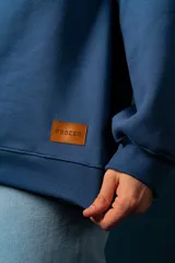 Buzo de felpa con medio cierre, diseño a bloques de color azul, blanco y rojo.