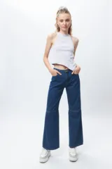 Top sin mangas de algodón color blanco, con escote redondo y terminación en pico diagonal en el ruedo inferior.