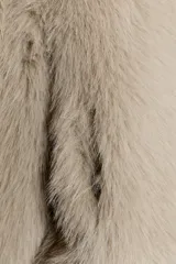 Cazadora de pelo sintético en color beige, con cuello solapa, manga larga y cierre frontal con cremallera. Presenta un diseño de corte recto y acabado suave.