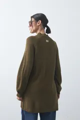 Vestido corto de punto en color beige, con cuello alto acanalado, mangas largas con puños ajustados y diseño holgado.
