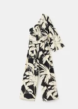 Mono largo de viscosa con diseño bicolor en negro y beige con estampado de hojas tropicales. Presenta un corte asimétrico de un solo hombro con manga larga holgada, pantalón de silueta recta y lazo ajustable en la cintura.