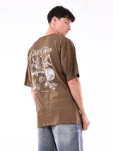 Remera de corte oversized color marrón, con cuello redondo, mangas cortas y frase estampada en el pecho.