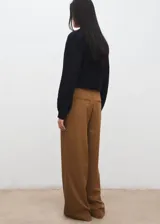 Pantalon de vestir color marron claro, de corte ancho y tiro medio, con bolsillos laterales.
