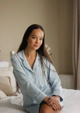 Camisa celeste con cuello clásico, cierre frontal con botones, manga larga con puños abotonados y bolsillo de parche en el pecho.