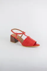 Sandalias de cuero rojo con diseño de tiras horizontales abullonadas en la parte delantera, punta fina, tira vertical central en forma de T y tira ajustable al tobillo. Poseen tacón cuadrado de madera de 6 cm.