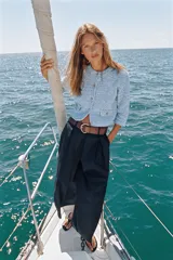 Chaqueta de punto en tono celeste, de cuello redondo, manga francesa y cierre frontal con botones dorados. Cuenta con bolsillos simulados con solapa y botones dorados en la parte delantera.
