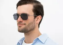 Lentes de sol INVU estilo aviador con montura plateada de metal y lentes polarizadas grises.