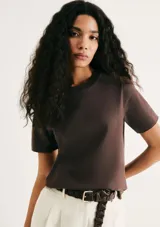 Camiseta de manga corta con cuello redondo, confeccionada en algodón de alta calidad. Presenta un corte clásico y versátil en color marrón oscuro.