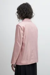 Blazer oversize de lino color rosa metalizado, con solapas de muesca, cierre con doble botonadura y bolsillos delanteros con solapa.