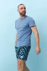 Bermuda de hombre azul con estampado de flores blancas y cordón ajustable en la cintura.