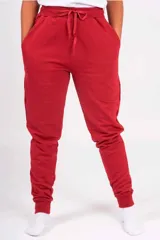 Pantalón de jogging unisex de color rojo, con bolsillos frontales, cintura elástica con cordón de ajuste y puños elásticos en los tobillos.