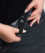 Pantalón de jean negro, modelo recto, con aberturas en el bajo de las piernas. Presenta cintura con elástico y botón mate.