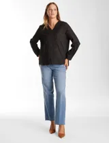 Blusa de algodón color negro con bordados florales al tono. Presenta escote en V con terminación festoneada y mangas largas con puños fruncidos.