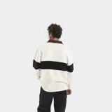 Buzo de estilo rugby con cuello camisero en contraste color crema, confeccionado en algodón y poliéster. Presenta una franja horizontal azul en el pecho con el logo de la marca estampado y diseño de manga larga.