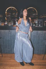 Pantalón holgado y fluido de tiro medio con diseño cruzado tipo pareo, confeccionado en tejido metalizado.