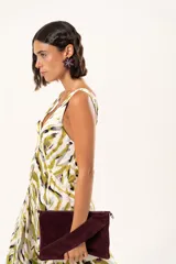 Vestido largo de tela sedosa con estampado abstracto en tonos verde oliva, blanco y negro. Presenta escote en V profundo, tirantes anchos y tajos laterales pronunciados en la falda.