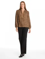 Blusa de gasa con estampado animal print, cuello a la base con escote en V y cierre frontal, manga larga con puños elastizados.
