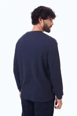 Buzo de manga larga con textura tipo waffle, cuello redondo y corte holgado.