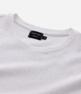 Remera de manga corta con cuello redondo, confeccionada en tejido tipo waffle con textura nido de abeja. Presenta un diseño liso y estructurado, ideal para un look casual y versátil.
