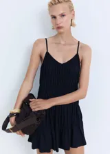 Vestido corto negro de tirantes finos, con escote en pico y diseño fruncido en la parte superior del cuerpo. Presenta un corte recto y fluido con un ligero vuelo en el ruedo.