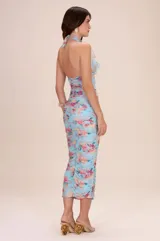 Vestido midi celeste con estampado floral multicolor, escote halter con volados fruncidos y diseño completamente fruncido al cuerpo.