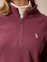 Buzo de polar con cuello alto y medio cierre frontal. Presenta un diseño de manga larga con puños elásticos y logo bordado en el pecho.