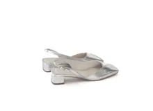 Zapato slingback de cuero color plateado, con punta cuadrada, escote en V y taco bajo cuadrado. Cuenta con pulsera trasera con hebilla ajustable.