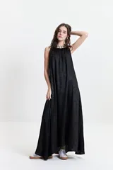 Vestido largo de silueta amplia y corte holgado, con breteles finos y escote redondeado. Presenta un frunce sutil en el escote delantero y trasero que genera una caída fluida. Confeccionado en tejido con acabado satinado.