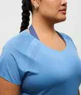 Remera deportiva de microfibra color negro, con cuello redondo, mangas cortas y detalles de perforaciones en los laterales de las mangas.
