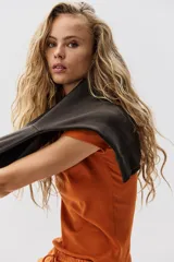 Remera de punto acanalado color naranja, de manga corta, cuello redondo y corte entallado.