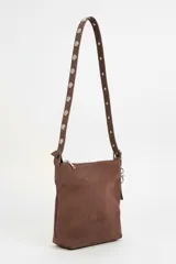 Cartera de hombro color marrón, con textura de gamuza, cierre de cremallera y detalle de argollas metálicas en el lateral.