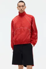 Short de ripstop negro con corte holgado, cintura elástica con cordón de ajuste y franjas laterales rojas con ribete blanco.