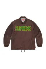 Campera tipo coach jacket de Supreme, color marrón, con cierre frontal de botones a presión, cuello clásico y cordón ajustable en el ruedo. Presenta el logo de la marca bordado en el pecho con letras grandes en color verde con borde amarillo.