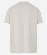 Remera color crema de corte regular, con cuello redondo y mangas cortas. Presenta un estampado rectangular en el pecho con elementos de la naturaleza en blanco y negro.