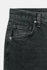 Jeans de tiro medio con corte baggy y pierna relajada. Presenta diseño de cinco bolsillos, cierre frontal con cremallera y botón, y bajo con vuelta marcada.