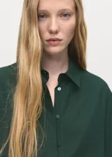 Camisa de lyocell verde oscuro, con cuello camisero, manga larga y diseño recto.
