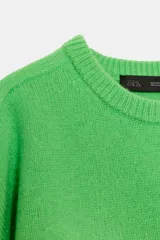 Jersey de punto liso confeccionado en lana 100%, con cuello redondo y mangas que llegan por debajo del codo.