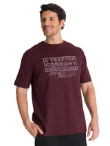 Remera de algodón color bordó con cuello redondo y manga corta. Presenta un gráfico estampado en el pecho con la leyenda A TRACTOR COMPANY PEORIA IL USA y una ilustración de maquinaria pesada.