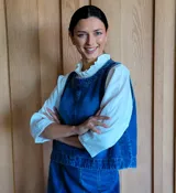 Chaleco de corte recto y largo a la cintura, confeccionado en denim con estampado de rayas verticales en tonos azul y blanco. Presenta cuello redondo y costuras visibles que definen su estructura.