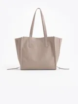 Bolso tipo tote de cuero color tostado con doble asa de hombro, detalles de hebillas metálicas en el frente y cierres laterales decorativos.
