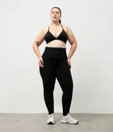 Legging deportiva de tiro alto confeccionada en microfibra, con diseño ajustado y cintura elástica ancha. Presenta un acabado liso sin costuras frontales, ofreciendo soporte y flexibilidad para actividades físicas.