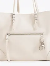 Cartera tote de cuero vacuno color blanco, de diseño estructurado con fuelles laterales expandibles mediante cierres y bolsillos externos con cierre y tiradores metálicos personalizados.
