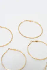 Set de aros dorados compuesto por tres pares de aros tipo argolla de diferentes tamaños y texturas, y cuatro pares de aros pequeños tipo broquel con diseños variados.