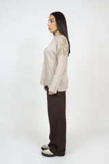 Pantalón de corte recto y tiro alto en color marrón, con bolsillos laterales y cierre frontal con botones.